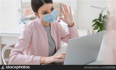 young business woman working from home wearing mask