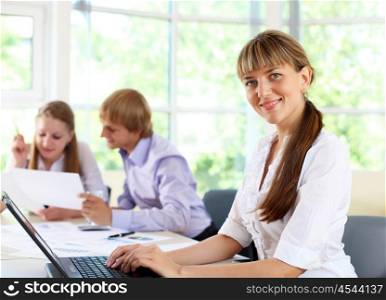 young business woman working in office with collegues on background