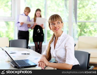 young business woman working in office with collegues on background