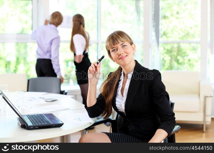 young business woman working in office with collegues on background