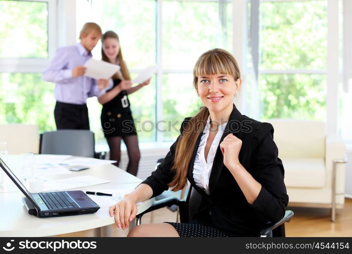 young business woman working in office with collegues on background