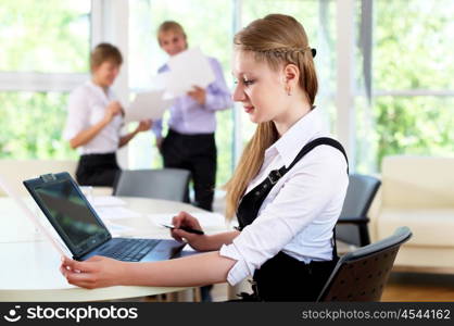 young business woman working in office with collegues on background