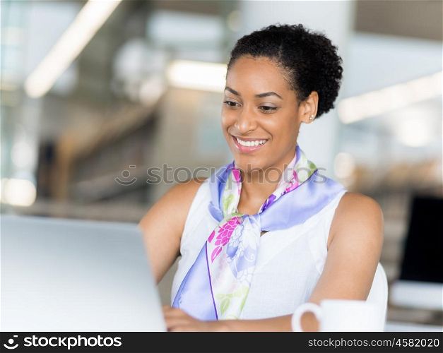 Young business woman working with laptop in office