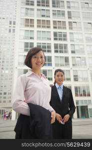 Young business women standing outside of CBD, portrait