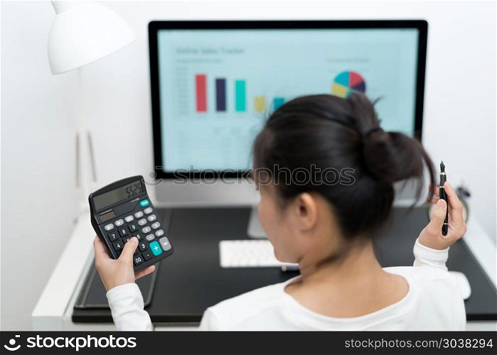 young business women work with calculator and computer desktop a. young business women work with calculator and computer desktop and pen on the modern work table