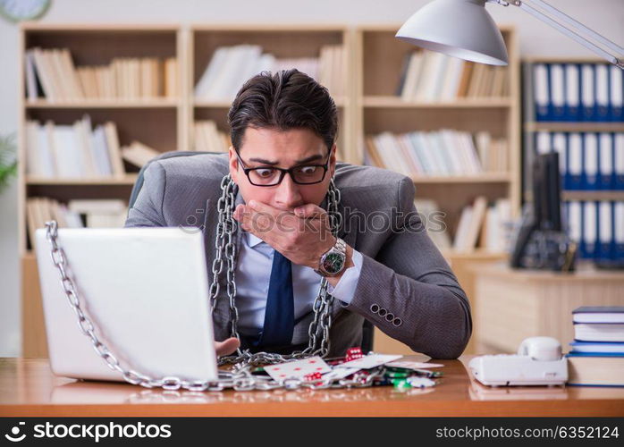 Young businessman addicted to online gambling cards playing in t. Young businessman addicted to online gambling cards playing in the office