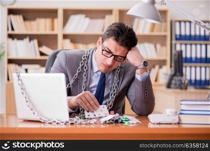 Young businessman addicted to online gambling cards playing in t. Young businessman addicted to online gambling cards playing in the office