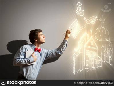Young businessman and collage. Image of young businessman with notebook drawing collage