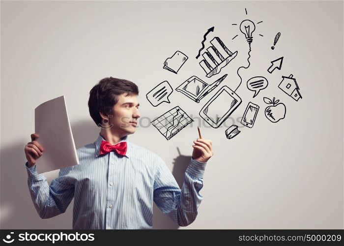 Young businessman and collage. Image of young businessman with notebook drawing collage