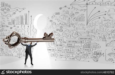 Young businessman and keyhole at background lifting big key above head. Find key to success