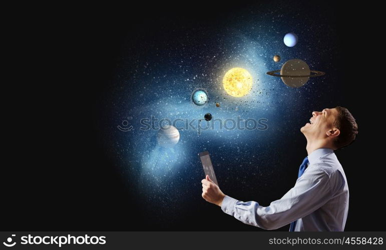 Young businessman and planets of space spinning around. Man exploring space