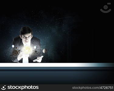 Young businessman and planets of space spinning around. Man exploring space