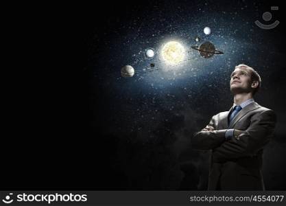 Young businessman and planets of sun system. Mysteries of space