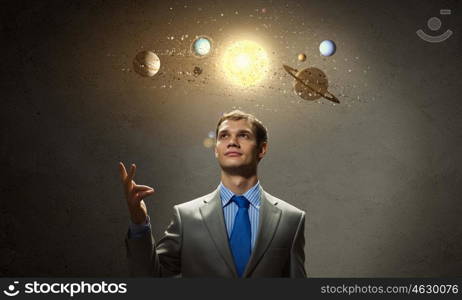 Young businessman and planets of sun system. Mysteries of space