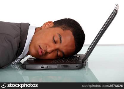 Young businessman asleep on laptop