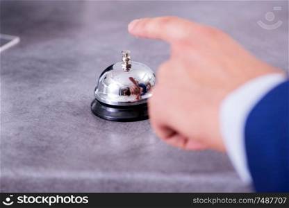 Young businessman at hotel reception. Hotel reception bell at the counter