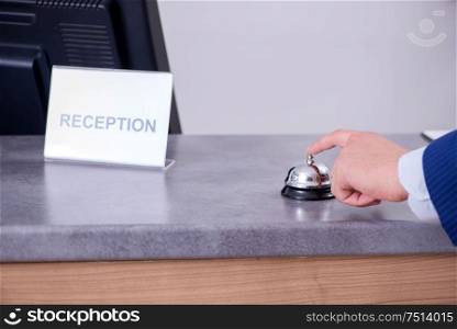 Young businessman at hotel reception. Hotel reception bell at the counter