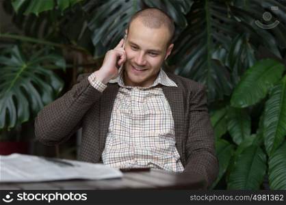 Young businessman at phone at green office