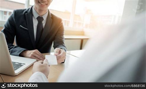 young businessman at the hiring interview in the office, meeting at office lobby, changing business cards