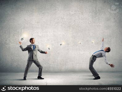 Young businessman benting from thrown light bulb