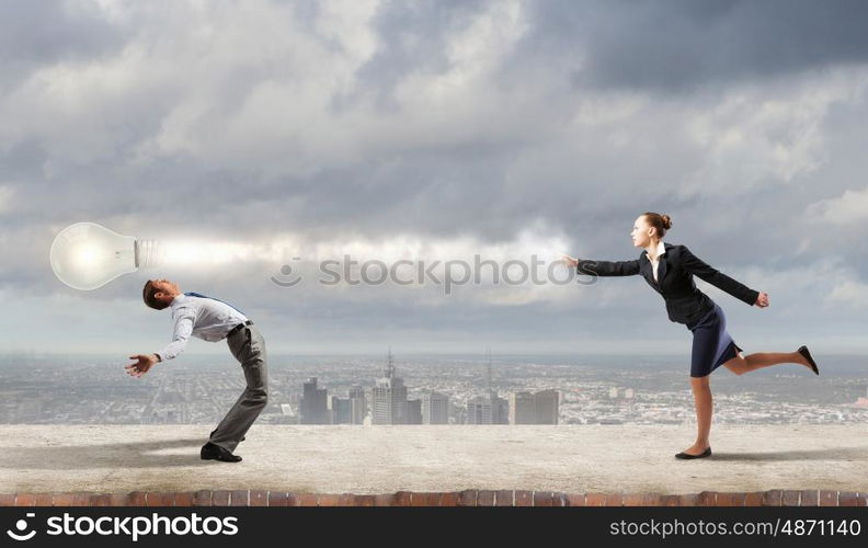 Young businessman benting from thrown light bulb