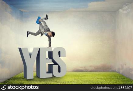 Young businessman breakdancer. Active businessman making handstand on word yes