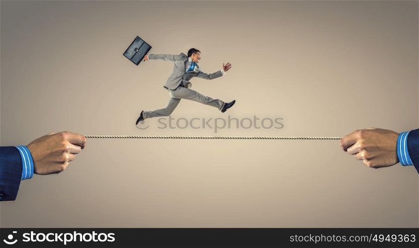 Young businessman breakdancer. Active young businessman making handstand on rope