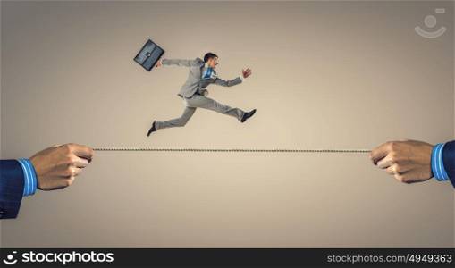 Young businessman breakdancer. Active young businessman making handstand on rope