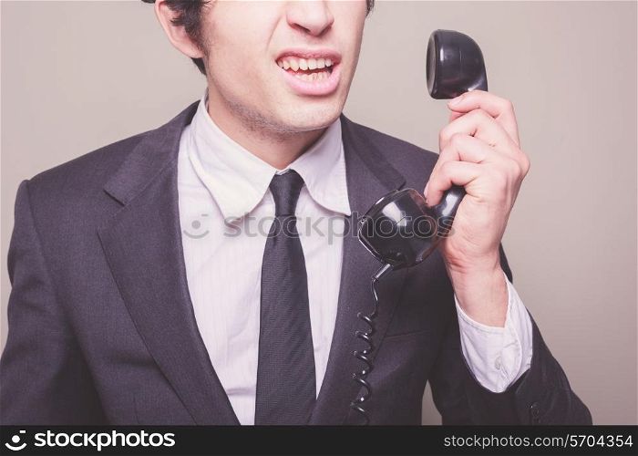 Young businessman can&rsquo;t believe what he is hearing on the phone