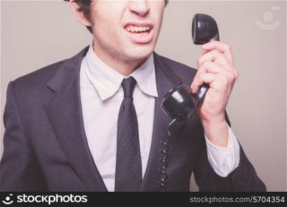 Young businessman can&rsquo;t believe what he is hearing on the phone