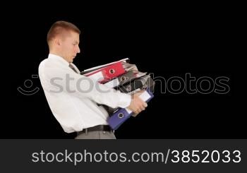 Young businessman carrying files and folders, against black