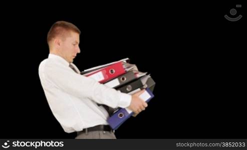Young businessman carrying files and folders, against black