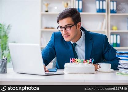 Young businessman celebrating birthday alone in office