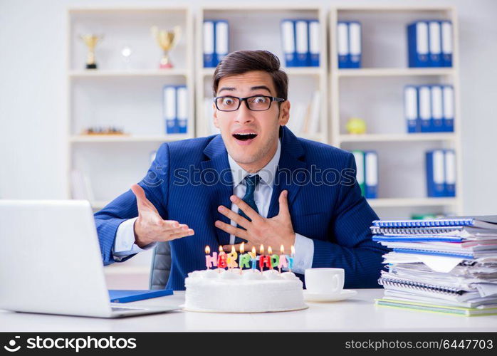 Young businessman celebrating birthday alone in office