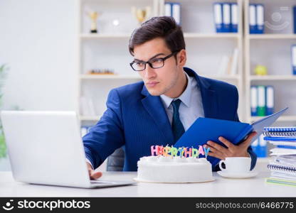 Young businessman celebrating birthday alone in office