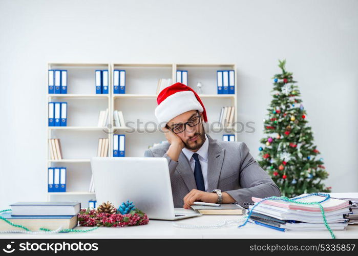 Young businessman celebrating christmas in the office