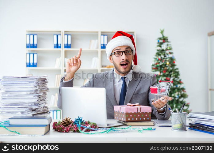 Young businessman celebrating christmas in the office