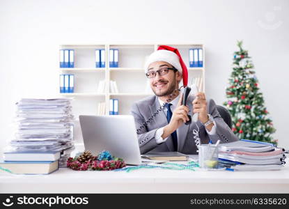 Young businessman celebrating christmas in the office