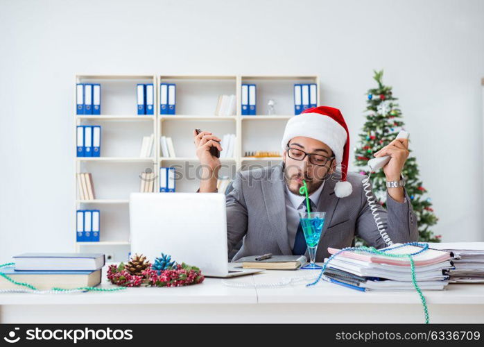 Young businessman celebrating christmas in the office