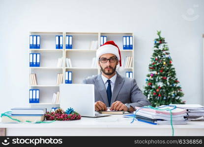 Young businessman celebrating christmas in the office