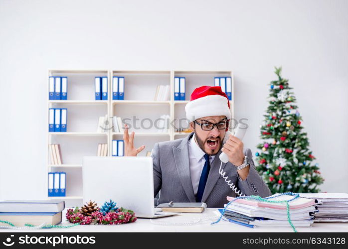 Young businessman celebrating christmas in the office