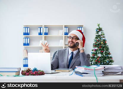 Young businessman celebrating christmas in the office