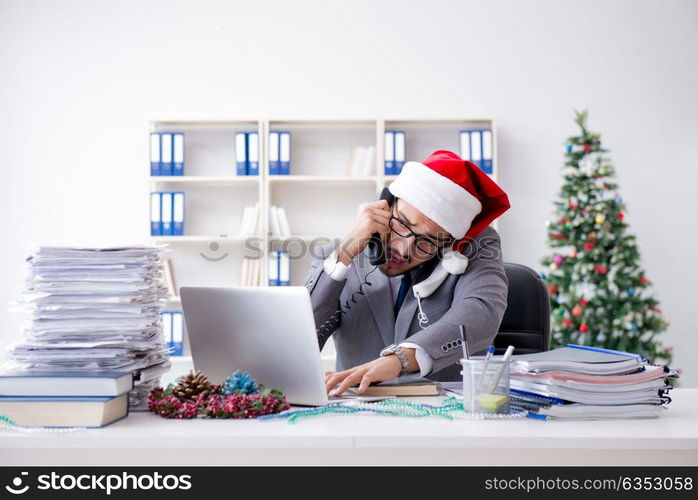 Young businessman celebrating christmas in the office