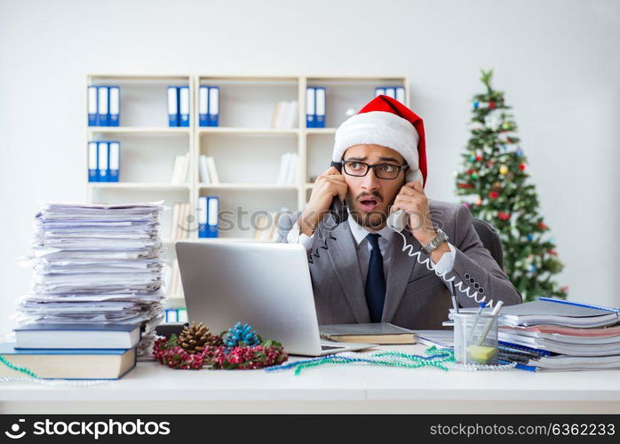 Young businessman celebrating christmas in the office