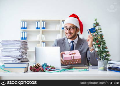 Young businessman celebrating christmas in the office. The young businessman celebrating christmas in the office