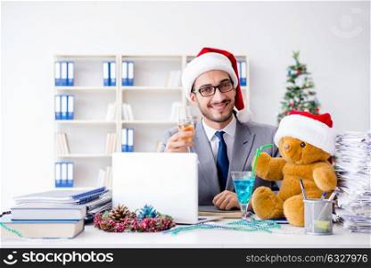 Young businessman celebrating christmas in the office. The young businessman celebrating christmas in the office