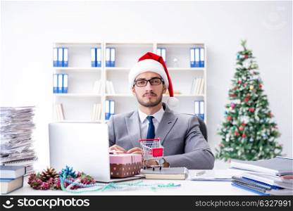 Young businessman celebrating christmas in the office. The young businessman celebrating christmas in the office