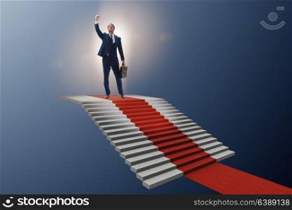 Young businessman climbing stairs and red carpet