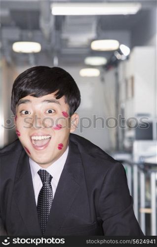 Young Businessman covered in lipstick kisses