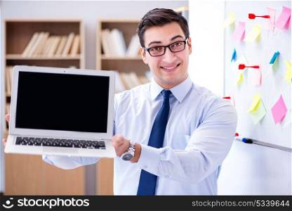 Young businessman demonstrating the screen of his laptop